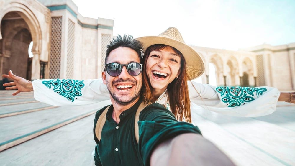 Honeymoon couple smiling outside the Hassan II Mosque, Casablanca