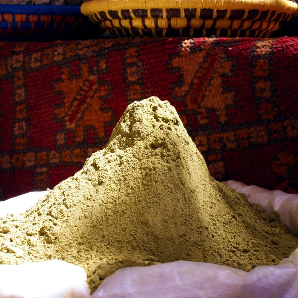 Henna and woven rugs for sale in a Rissani souk stall, Morocco