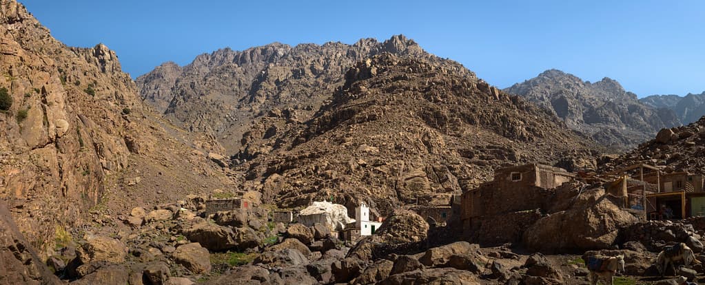 Trekkers pausing at the Sidi Chamharouch shrine for a tea break on the climb toward Toubkal base camp