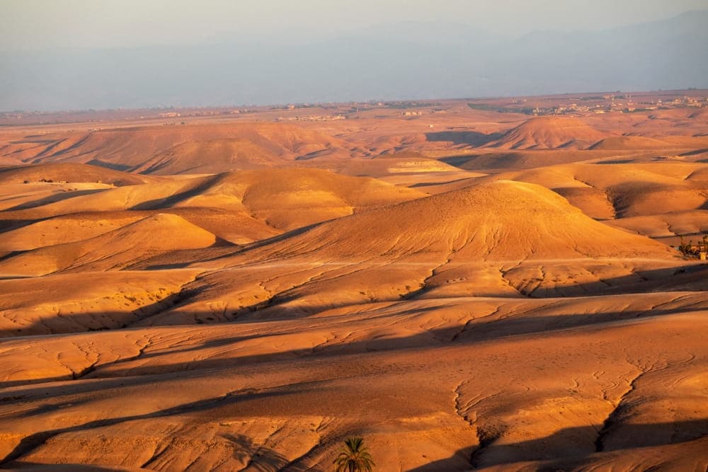 Golden sunset light over the rocky dunes of Agafay Desert near Marrakech