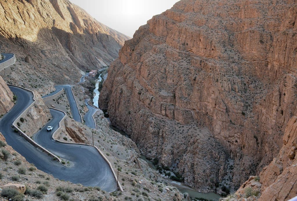 Dades Valley winding serpentine mountain road at dusk, long exposure light trails location Morocco