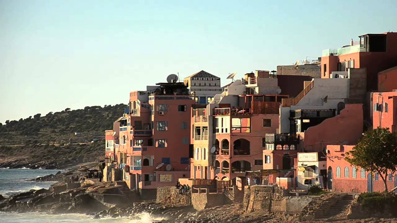 Village core of Taghazout with fishing boats and cafés along the shoreline, Morocco